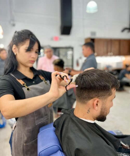 barber giving haircut to her client