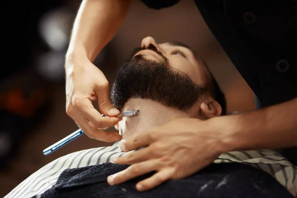 barber shaving his clients beard