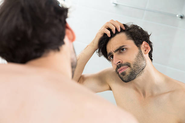 Caucasian adult man checking hairline.Hair loss problems Navigating Hair Loss