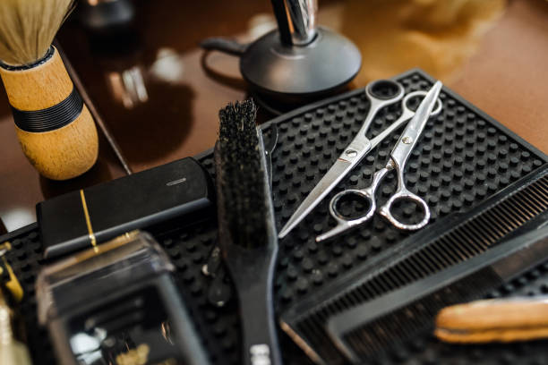 Close-up of haircutting scissors and combs on napkin. High angle view of equipment on table. Focus is on tools in barbershop.
