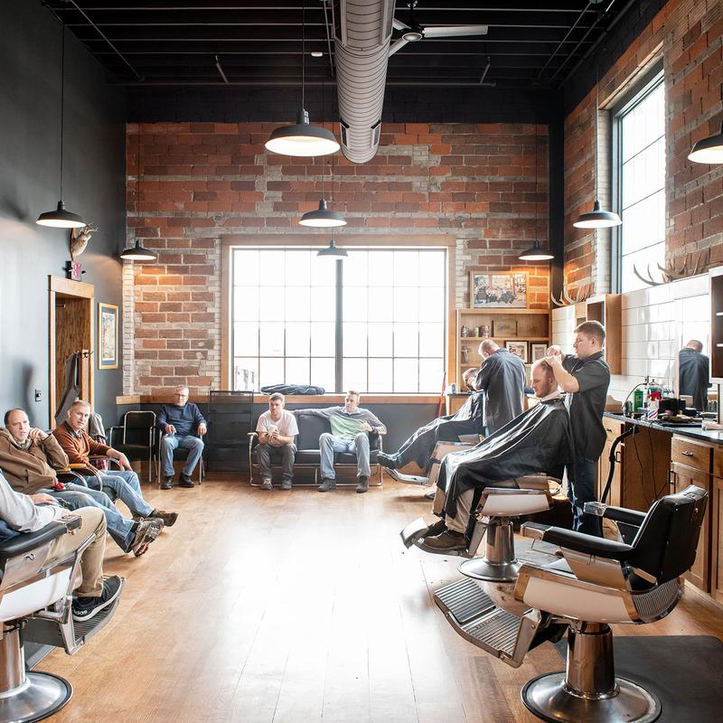 inside a barber shop with a lot of customer