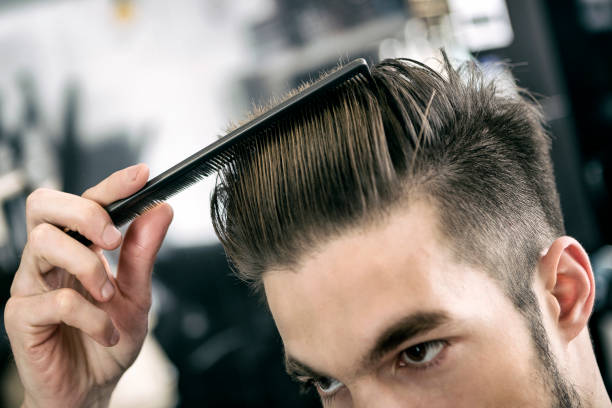 Man combing washed hair at hairdresser