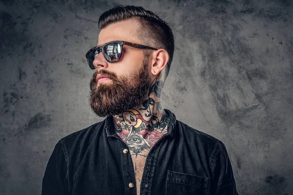 man with neck tattoos and shade staring side ways