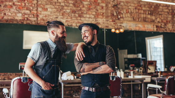 two barber looking at each other laughing