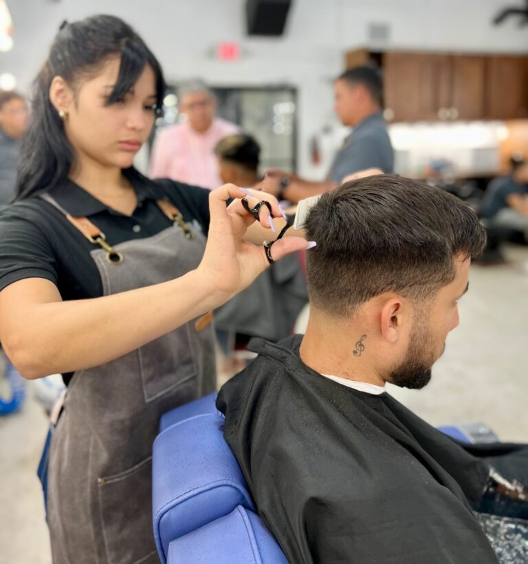 young barber cutting her client's hair